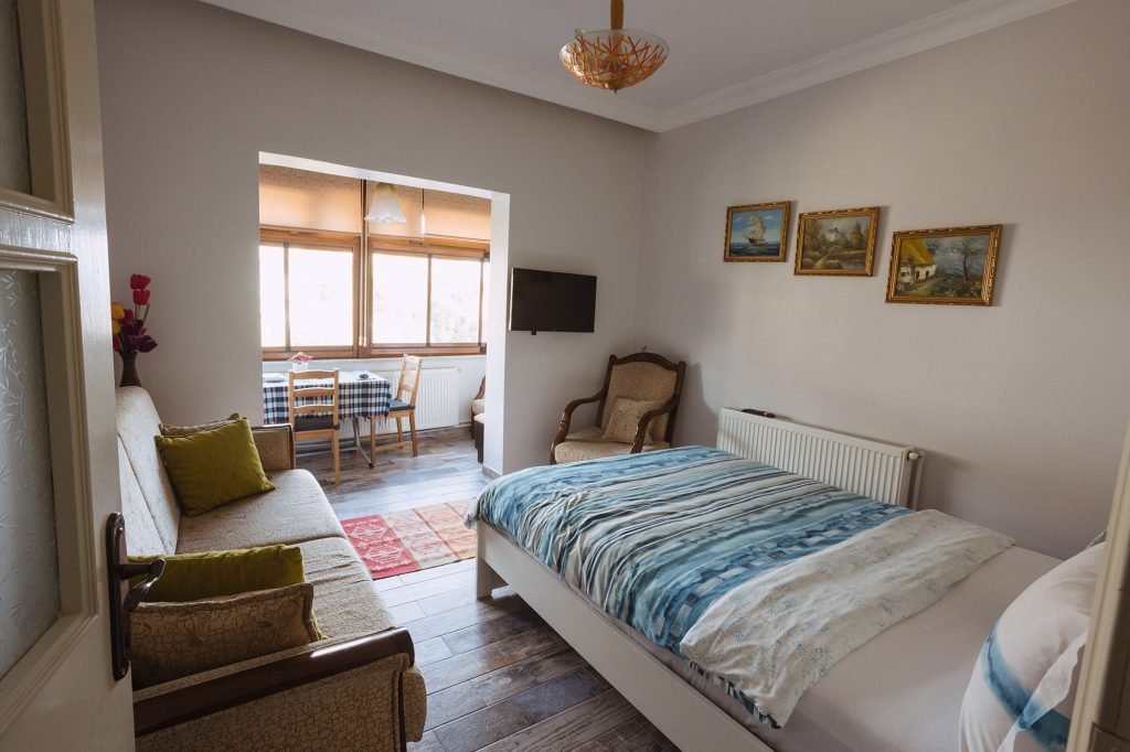 A single bed and sitting corner in the second room